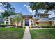 Charming home featuring a blue front door, arched windows and lush, manicured landscaping at 4819 Shoreline Cir, Sanford, FL 32771