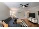 Comfortable living room with a plush gray sectional, ceiling fan, and wood-look flooring at 4819 Shoreline Cir, Sanford, FL 32771