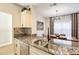 Modern kitchen with granite countertops flows to dining area with custom chandelier and window at 4833 Cypress Woods Dr # 4101, Orlando, FL 32811