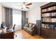 Inviting home office features built-in bookshelves, a comfortable couch, and natural light from the window at 4833 Cypress Woods Dr # 4101, Orlando, FL 32811