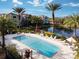 The community pool is surrounded by swaying palm trees, lounge chairs, and verdant greenery at 4833 Cypress Woods Dr # 4101, Orlando, FL 32811