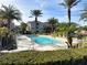 A community swimming pool with lounge chairs around the pool, palm trees and landscaping at 4833 Cypress Woods Dr # 4101, Orlando, FL 32811