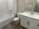 Bathroom featuring a tub, toilet, wood-look tile floor, and white cabinets at 5099 Prairie Preserve Run, St Cloud, FL 34772