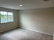 This is a bedroom with gray carpet, beige walls, and a window view of trees and the lake at 5099 Prairie Preserve Run, St Cloud, FL 34772