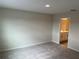 This is a bedroom with gray carpet and a bathroom; it is move-in ready at 5099 Prairie Preserve Run, St Cloud, FL 34772