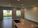 Open-concept living room with tile floors, recessed lighting, and sliding glass doors to the backyard at 5099 Prairie Preserve Run, St Cloud, FL 34772