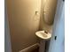 Cozy half-bathroom features a modern pedestal sink and a round mirror at 5099 Prairie Preserve Run, St Cloud, FL 34772