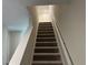 Carpeted staircase with a white handrail leading upstairs at 5099 Prairie Preserve Run, St Cloud, FL 34772