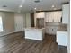 Modern kitchen boasts white cabinetry, a center island with sink, and wood-look floors at 5103 Prairie Preserve Run, St Cloud, FL 34772