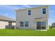 Exterior rear of house showing large sliding glass door, neutral siding, and spacious green yard at 5109 Forget Me Not Ave, Lake Hamilton, FL 33851