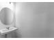 A well-lit bathroom featuring a modern pedestal sink, a large mirror, and neutral walls at 5109 Forget Me Not Ave, Lake Hamilton, FL 33851