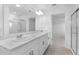 Bathroom featuring double sinks, sleek white cabinets, and a glass-enclosed shower at 5109 Forget Me Not Ave, Lake Hamilton, FL 33851