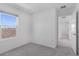 A bright bedroom is accentuated by a large window, carpeted floor, and an adjacent hallway entrance at 5109 Forget Me Not Ave, Lake Hamilton, FL 33851