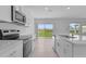 Bright kitchen featuring stainless steel appliances, white cabinets, and a large island with a sliding glass door at 5109 Forget Me Not Ave, Lake Hamilton, FL 33851