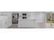 Bright open-concept kitchen with stainless steel appliances, white cabinets, a kitchen island, and sliding doors to the backyard at 5109 Forget Me Not Ave, Lake Hamilton, FL 33851