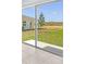 A patio view features a large grassy yard, an adjacent house, and a clear blue sky at 5109 Forget Me Not Ave, Lake Hamilton, FL 33851