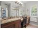 Bathroom vanity features granite countertops, storage cabinets, and stylish decor with natural light at 5489 Baldwin Park St, Orlando, FL 32814