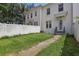 Inviting townhouse featuring a green lawn, white picket fence, and a charming front entrance at 5489 Baldwin Park St, Orlando, FL 32814