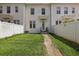 Exterior view of a well-maintained townhome with a grassy front yard and walkway at 5489 Baldwin Park St, Orlando, FL 32814
