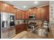 Functional kitchen featuring stainless steel appliances, wooden cabinets, and granite countertops at 5489 Baldwin Park St, Orlando, FL 32814