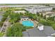 Aerial view of the community pool and recreation area surrounded by trees and nearby residential streets at 5489 Baldwin Park St, Orlando, FL 32814