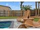 Inviting pool area with stylish wicker chairs and a small table for outdoor relaxation at 550 Birch Ct, Altamonte Springs, FL 32714