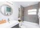 Bathroom boasts stylish mirror, tiled shower and tub, and neutral wall color at 631 Trailwood Dr, Altamonte Springs, FL 32714