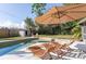 Inviting backyard pool area with lounge chairs, sun umbrella, and private fenced-in yard at 631 Trailwood Dr, Altamonte Springs, FL 32714