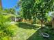 Spacious backyard featuring a lush green lawn, mature trees, and a screened porch, perfect for outdoor relaxation at 6434 Tidewave St, Orlando, FL 32822