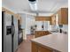 Open kitchen with light wood cabinets, stainless appliances, and breakfast bar at 670 N Sparkman Ave, Orange City, FL 32763