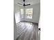 Bright bedroom with modern ceiling fan, two windows, and beautiful grey wood flooring at 7147 Yacht Basin Ave # 119, Orlando, FL 32835