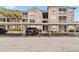 Condo building exterior showing a covered parking area, neutral color scheme, and manicured landscaping with palm trees at 7147 Yacht Basin Ave # 119, Orlando, FL 32835