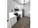 Modern kitchen with white cabinets, stainless steel appliances, and stylish light fixture at 7147 Yacht Basin Ave # 119, Orlando, FL 32835