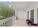 Covered balcony with comfortable seating and views of lush landscaping at 7630 Heritage Crossing Way # 302, Reunion, FL 34747