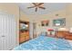 Comfortable bedroom with a ceiling fan and an entertainment center at 7630 Heritage Crossing Way # 302, Reunion, FL 34747