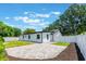 A vast backyard is showcased with a manicured lawn and modern brick patio at 7664 Clubhouse Estates Dr, Orlando, FL 32819