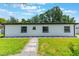 A backyard showcasing a well-maintained lawn and the modern design of the home's exterior at 7664 Clubhouse Estates Dr, Orlando, FL 32819