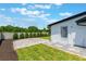 Landscaped backyard with brick patio, green lawn, modern fence, and access door on a sunny day at 7664 Clubhouse Estates Dr, Orlando, FL 32819