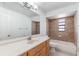 Bathroom featuring a shower, bathtub, window, large mirror, and a light wood cabinet at 7664 Clubhouse Estates Dr, Orlando, FL 32819