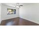 A bedroom with a ceiling fan and hardwood floors shows a tranquil view from the window at 7664 Clubhouse Estates Dr, Orlando, FL 32819