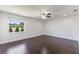 Bright bedroom with hardwood floors, ceiling fan, and a window with a view of greenery at 7664 Clubhouse Estates Dr, Orlando, FL 32819