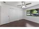 Bedroom featuring three closets, a ceiling fan, and a window that offers a view of the front yard at 7664 Clubhouse Estates Dr, Orlando, FL 32819