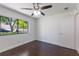 A bedroom with a ceiling fan, hardwood floors, and a window offers a glimpse of the greenery outside at 7664 Clubhouse Estates Dr, Orlando, FL 32819