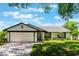 Charming single-story home with a lush lawn, brick driveway, and attached two-car garage at 7664 Clubhouse Estates Dr, Orlando, FL 32819