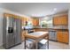 Well-lit kitchen with stainless steel appliances, wooden cabinets, and a portable island at 7664 Clubhouse Estates Dr, Orlando, FL 32819