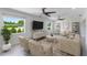 A modern living room with two ceiling fans, light-colored furniture, and plenty of natural light at 7664 Clubhouse Estates Dr, Orlando, FL 32819