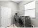 Functional laundry room with modern washer and dryer units, shelving, and a window at 829 Lakeworth Cir, Lake Mary, FL 32746