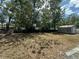 Large backyard with mature trees, a fence for privacy, and a storage shed for tools and equipment at 890 Emerald Dr, Mount Dora, FL 32757