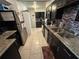 Well-lit kitchen boasts dark cabinets, granite countertops, tile backsplash, and stainless appliances at 890 Emerald Dr, Mount Dora, FL 32757