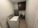 Functional laundry room with a washer, water heater, storage shelves, and tiled floors at 890 Emerald Dr, Mount Dora, FL 32757